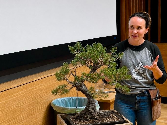 Jennifer Price gestures near a small pine bonsai during her seminar.