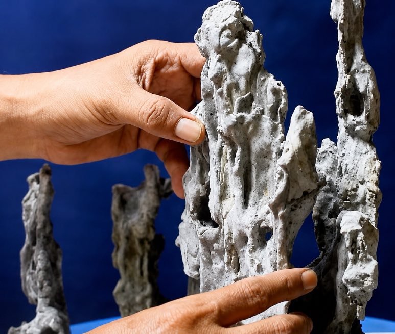 Pedro Morales shaping an artificial rock formation by hand.