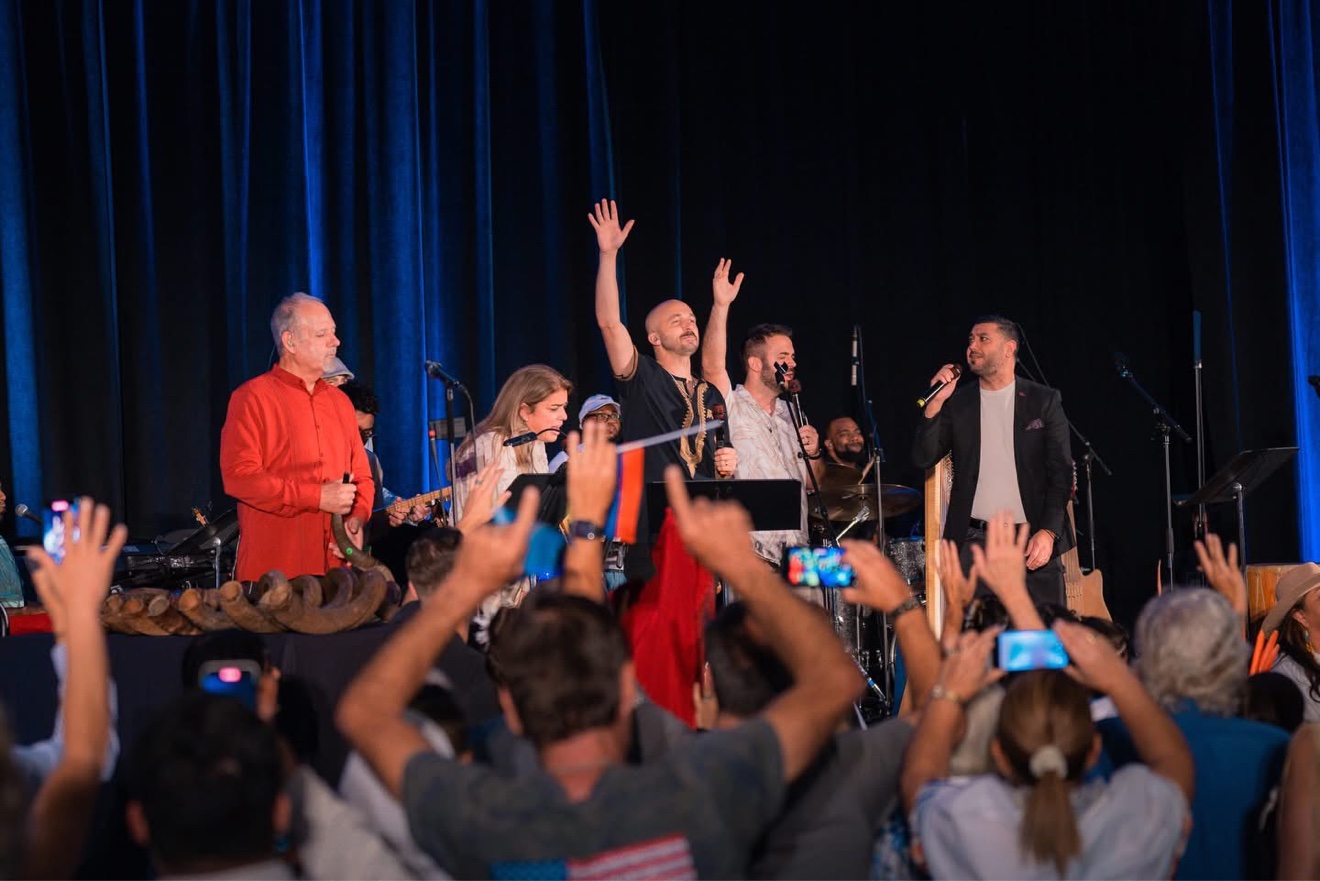 Worship leaders on stage before a large crowd